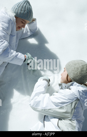 Two teen girls drawing in snow Stock Photo