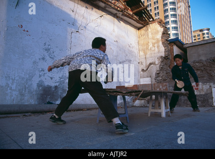 Pingong Boys kids playing with a make shift ping pong table in a hutong in central Beijing Stock Photo