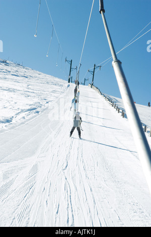 Young skiers using ski lift on ski slope, low angle view Stock Photo