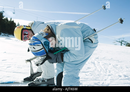 Two young skiers bending over, looking at camera, side view Stock Photo