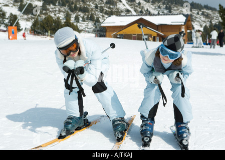 Two young skiers crouching together, looking at camera Stock Photo