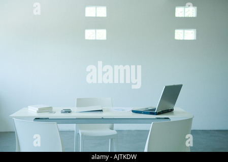 Laptop computer and cell phone on desk in office Stock Photo
