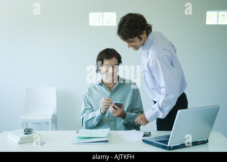 Two businessmen looking at notebook together in office Stock Photo