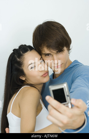 Young couple taking self portrait with digital camera Stock Photo