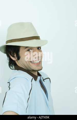 Young man looking over shoulder at camera, smiling, portrait Stock Photo