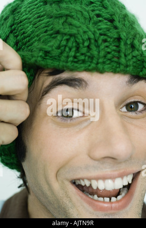 Young man wearing knit hat, smiling at camera, portrait Stock Photo