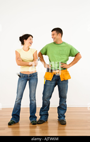 Couple with tools standing and smiling in home Stock Photo