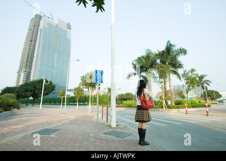 Young woman waiting to cross street Stock Photo