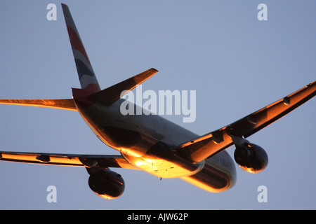 British Airways Boeing 777 just after take off in reflecting sunset light at Heathrow Airport, London, England, UK. Stock Photo