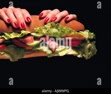 Lifestyle. Woman. Food. Hands holding ham salad roll. Stock Photo