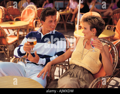 Close-up of young, romantic couple drinking in outdoor restaurant / bar / street café. France. Stock Photo