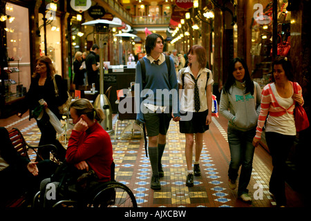 A boy and girl in school uniforms walking and looking at shops in Sydney's Victorian era Strand Arcade in Sydney Australia. Stock Photo