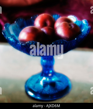 square picture of blue stemmed bowl of red plums Stock Photo