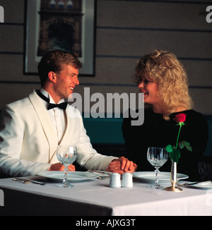 Close-up of happy young couple in restaurant waiting for dinner to be served. Stock Photo