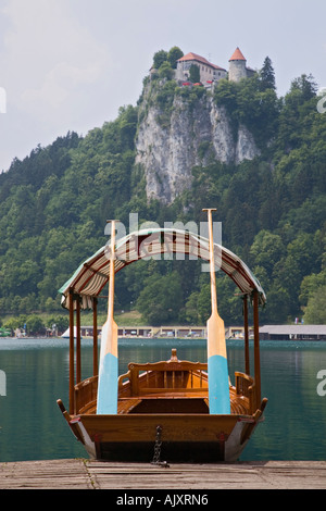 Lake Bled in summer with oars on traditional wooden pletnja rowing boat and castle beyond on cliff. Bled Slovenia Stock Photo