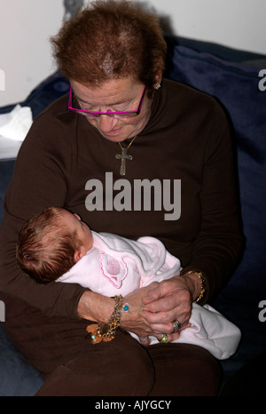 Newborn Baby Girl Being Held by Great Grandmother Stock Photo