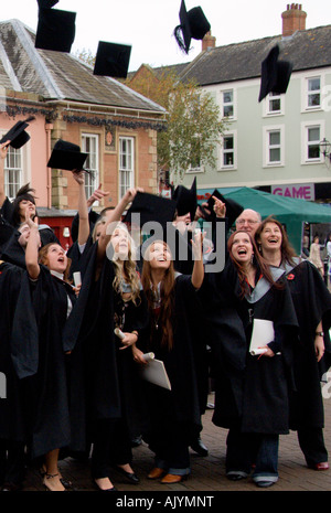 Group of happy student and staff throwing hats into air after graduation ceremony University of Cumbria Carlisle England Stock Photo