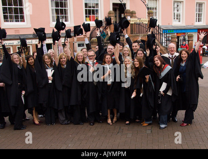 Group of happy student and staff throwing hats into air after graduation ceremony University of Cumbria Carlisle England Stock Photo