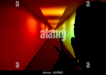 man with cell phone standing in multicolored hospital hallway Stock Photo