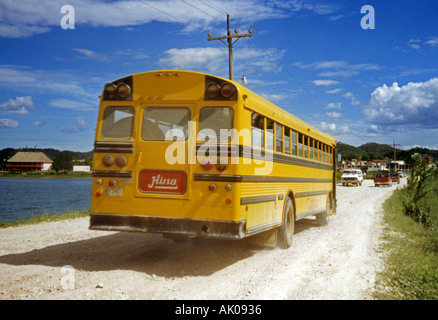 Characteristic tradition bright yellow local bus cross rural Lake Peten Itza Flores Island Guatemala Central Latin America Stock Photo