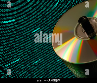 Close up of a stack of CD DVD disks on an angle with a curved field of binary code in the background Stock Photo