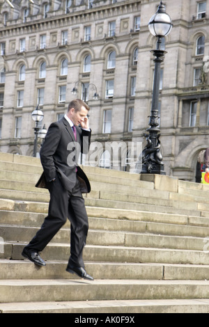 UK England Lancashire,Liverpool,Lime Street,steps stairs staircase,man men male,menal,mobile,smartphone cell phone phones,checking looking reading tex Stock Photo