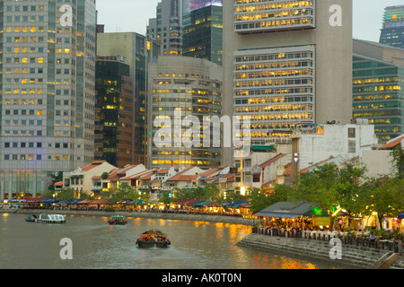Dusk view of restored old buildings on Boat Quay along the Singapore River backed by office towers in Raffles Place Singapore Stock Photo