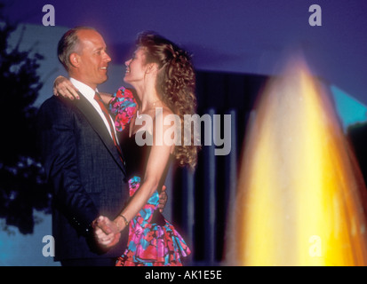 couple dancing outdoors by colorful lighted fountain Stock Photo