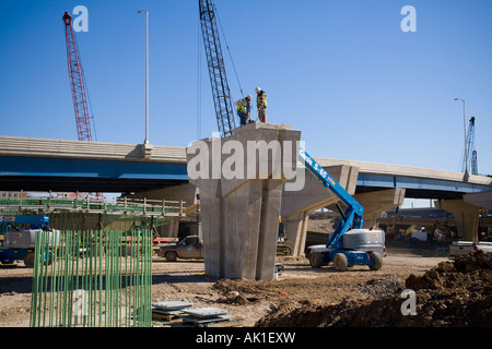 Two workmen standing on a concrete girder part of the Marquette interchange project overpass construction Milwaukee Wisconsin Stock Photo
