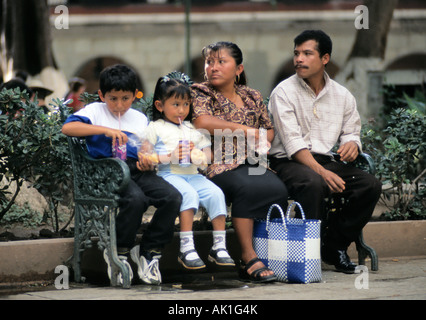Family sitting on bench at Zocalo in Oaxaca, Mexico Stock Photo