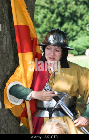 Woman flag bearer with helmet and sward at medieval reenactment Stock Photo