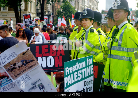 Metropolitan police officers stand outside Downing Street while anti-war protesters file past. Copyright Terence Bunch Stock Photo