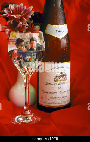 A couple dining at a fine restaurant are reflected in a bottle of excellent wine Stock Photo