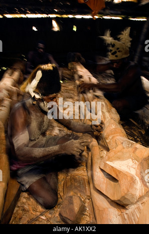 Asmat tribal men carving totem poles in Omandeseb Village, Irian Jaya, Indonesia. Stock Photo