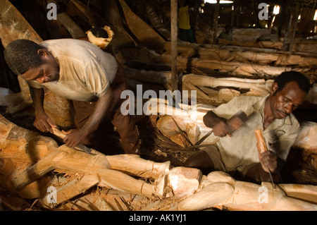 Asmat tribal men carving totem poles in Omandeseb Village, Irian Jaya, Indonesia. Stock Photo