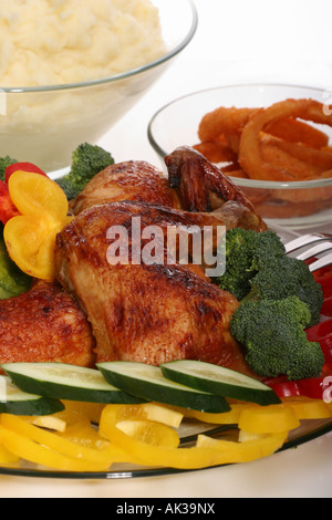 Closeup of roasted chicken meat served on a plate with vegetable garnish overhed nobody vertical in USA US hi-res Stock Photo