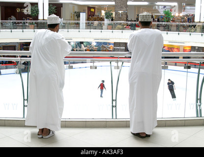 Two Arab men watching skaters at iceskating  rink in the City Centre in Doha,Qatar Stock Photo