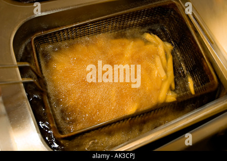 deep fryed chips being deep fried for eating Stock Photo