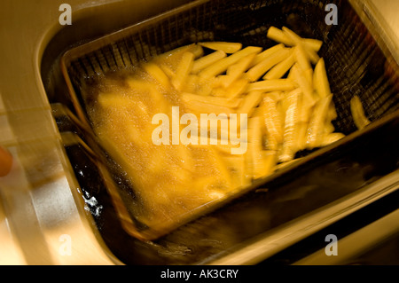 deep fryed chips being deep fried for eating Stock Photo