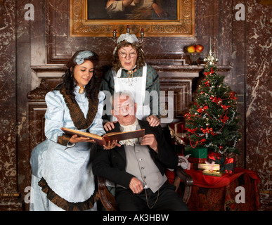 Vintage christmas scene of a victorian family singing christmas carols Stock Photo