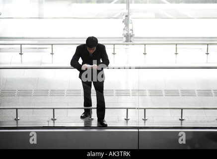 Businessman playing handheld video game, high angle view Stock Photo