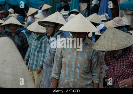 Many women wearing cone shaped hats at the fish market Hoi An Vietnam Stock Photo