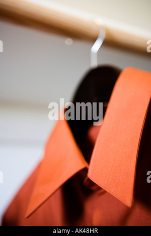 Red Collared Dress Shirt Hanging in Closet Stock Photo