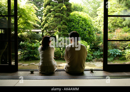 Mature man and woman relaxing in "Front or Back Yard", rear view Stock Photo