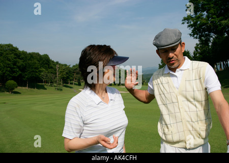 Mature couple walking on golf course, close-up Stock Photo