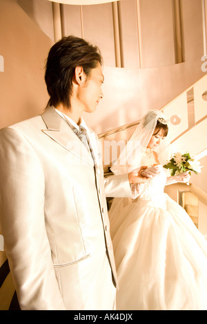 Bride and groom walking down the staircase, close-up Stock Photo