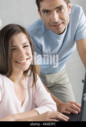 Couple using laptop, smiling Stock Photo