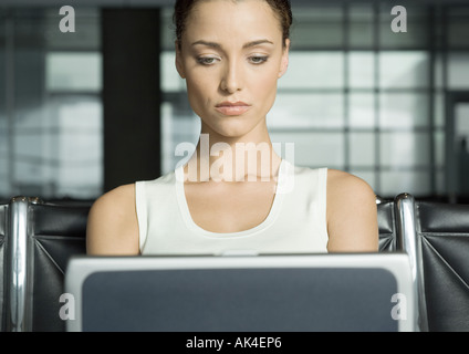 Female traveler using laptop in airport lounge Stock Photo