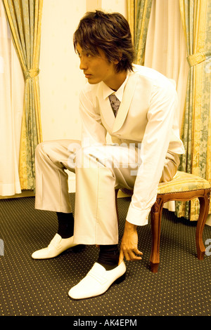 Young man in a suit wearing shoes Stock Photo