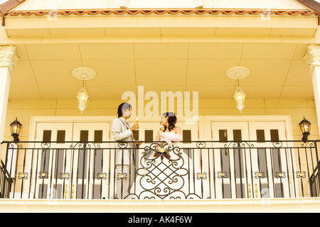 Newlywed couple toasting to each other on balcony Stock Photo
